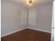 Neutral bedroom featuring two windows, wood floor and modern light fixture at 4125 Fastnet Lane, Duluth, GA 30096
