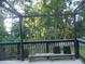 A serene outdoor deck with wooden furniture and a view of the lush surrounding trees at 4125 Fastnet Lane, Duluth, GA 30096