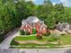 Aerial view of a beautiful red brick home with lush landscaping in a wooded neighborhood at 10119 Azalea Dr, Covington, GA 30014
