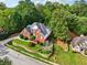 Aerial shot of a red brick home with well-manicured lawns in a serene, wooded neighborhood at 10119 Azalea Dr, Covington, GA 30014