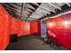Basement area with red walls, platform stage, and exposed ducts for personalization at 10119 Azalea Dr, Covington, GA 30014
