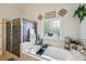 This bathroom features a soaking tub, a glass block window, and decorative elements at 10119 Azalea Dr, Covington, GA 30014