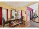 Dining area with a wooden table, bench, red curtains and terra cotta style tile floors at 10119 Azalea Dr, Covington, GA 30014