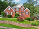 Elegant red brick home with a well-maintained lawn, trees and classic curb appeal at 10119 Azalea Dr, Covington, GA 30014