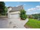 Spacious driveway leading to a two-car garage, showcasing the home's exterior and landscaping at 10119 Azalea Dr, Covington, GA 30014