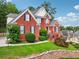 Charming red brick home with lush landscaping and a welcoming front porch at 10119 Azalea Dr, Covington, GA 30014