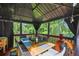 Outdoor gazebo featuring a dining table, curtains, and a view of the wooded backyard at 10119 Azalea Dr, Covington, GA 30014