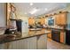 Kitchen with wooden cabinets, granite countertops, and modern appliances, including a stainless steel dishwasher at 10119 Azalea Dr, Covington, GA 30014