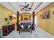 This main bedroom features a tray ceiling, a ceiling fan, a seating area, and an ensuite at 10119 Azalea Dr, Covington, GA 30014