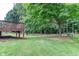 Grassy backyard with wooded area and deck at 1049 Braddock Cir, Woodstock, GA 30189