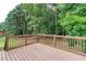 View of home's deck with wooden railing and wooded backyard at 1049 Braddock Cir, Woodstock, GA 30189