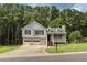 Charming two-story home with gray siding, black shutters, and a two-car garage, nestled on a large wooded lot at 1049 Braddock Cir, Woodstock, GA 30189