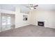 Spacious living room featuring a cozy fireplace, large windows, and an open layout leading to the kitchen at 1049 Braddock Cir, Woodstock, GA 30189