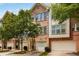 Charming brick townhome exterior featuring an attached garage and lush green trees at 1403 Ashford Creek Ne Cir, Atlanta, GA 30319