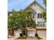 Charming brick townhome exterior featuring a single-car garage and lush shade tree at 1403 Ashford Creek Ne Cir, Atlanta, GA 30319
