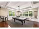 Well-lit game room with a covered pool table and a view of the outdoors from multiple windows at 1403 Ashford Creek Ne Cir, Atlanta, GA 30319