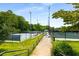 View of tennis courts with manicured landscaping and lighting, perfect for daytime or evening play at 1403 Ashford Creek Ne Cir, Atlanta, GA 30319