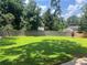 Green grass backyard, surrounded by trees, provides plenty of space at 1725 Spindle Top Sw Ct, Lilburn, GA 30047