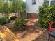 View of backyard featuring green shrubs with a hose lying on top of dead leaves at 1725 Spindle Top Sw Ct, Lilburn, GA 30047