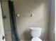 This bathroom has a shower with a shower curtain, a toilet, and a towel rack at 1725 Spindle Top Sw Ct, Lilburn, GA 30047