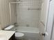 Bathroom with white tile walls, a shower-tub combo, and a toilet at 1725 Spindle Top Sw Ct, Lilburn, GA 30047