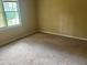 This bedroom has carpet, natural light from the window, and neutral colored walls at 1725 Spindle Top Sw Ct, Lilburn, GA 30047