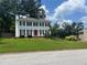 Charming two-story home with a red front door and lush front lawn at 1725 Spindle Top Sw Ct, Lilburn, GA 30047