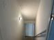 This hallway has painted white walls with a light fixture and an adjacent staircase at 1725 Spindle Top Sw Ct, Lilburn, GA 30047