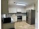 Well-lit kitchen featuring stainless steel appliances, white cabinets, and ample counter space at 1725 Spindle Top Sw Ct, Lilburn, GA 30047