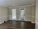 Spacious living room with wood floors, neutral walls, and a door leading to the outside at 1725 Spindle Top Sw Ct, Lilburn, GA 30047