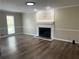 Bright living room featuring a fireplace with a white mantel, dark wood floors, and natural light at 1725 Spindle Top Sw Ct, Lilburn, GA 30047