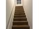 This staircase has carpeted stairs and a white handrail at 1725 Spindle Top Sw Ct, Lilburn, GA 30047