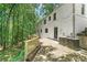Spacious backyard with stone patio and natural wood railing, complemented by mature trees, and white brick exterior at 4103 Statewood Ne Rd, Atlanta, GA 30342