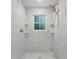 Elegant walk-in shower featuring marble tiling, a rainfall shower head, and built-in shelving niches at 4103 Statewood Ne Rd, Atlanta, GA 30342