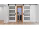 Stylish bar area with sliding barn doors, built-in mini-fridge and ambient lighting at 1355 Lockwood Sw Dr, Atlanta, GA 30311