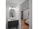 Stylish bathroom features a modern vanity, arched mirror, and a glimpse into the adjacent bedroom at 1355 Lockwood Sw Dr, Atlanta, GA 30311
