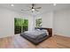 Bright bedroom with a sleek platform bed, hardwood floors, and balcony access with wooded views at 1355 Lockwood Sw Dr, Atlanta, GA 30311
