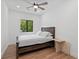 Minimalist bedroom featuring a wood bed frame, light wood floors and a leafy view from the window at 1355 Lockwood Sw Dr, Atlanta, GA 30311