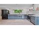 Modern kitchen featuring stainless steel appliances, gray cabinetry, and a stylish island with a sink and ample counter space at 1355 Lockwood Sw Dr, Atlanta, GA 30311