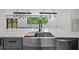 Close-up of kitchen sink with marble countertops and modern light fixtures at 1355 Lockwood Sw Dr, Atlanta, GA 30311