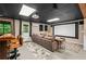 Finished basement with a large screen, a bar area, drop ceiling, and a comfortable sectional sofa at 5130 Stoneywood Se Cir, Mableton, GA 30126