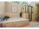 Bright bathroom features a soaking tub with tile surround and glass enclosed shower at 5130 Stoneywood Se Cir, Mableton, GA 30126