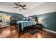 Comfortable bedroom features a ceiling fan, hardwood floors, and soothing teal and white decor at 5130 Stoneywood Se Cir, Mableton, GA 30126