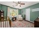 Cozy Bedroom featuring a crib, a glider, a patterned rug, and natural light at 5130 Stoneywood Se Cir, Mableton, GA 30126