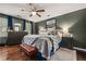 Well-lit main bedroom featuring an elegant ceiling fan, a bed with plush pillows, and wood floors at 5130 Stoneywood Se Cir, Mableton, GA 30126