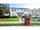 Two-story townhome with neutral siding, black shutters, manicured lawn, and brick mailbox at 134 Odyssey Turn, Conyers, GA 30012