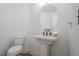 Modern half bathroom with pedestal sink, gold faucet, oval mirror, and sleek toilet at 86 Whitlock Sw Sq, Marietta, GA 30064