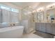 Bright bathroom featuring a soaking tub, glass shower, and double vanity with gold hardware at 86 Whitlock Sw Sq, Marietta, GA 30064
