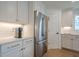 Bright kitchen features white cabinets, stainless steel refrigerator, and gold hardware accents at 86 Whitlock Sw Sq, Marietta, GA 30064