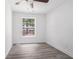 Empty bedroom showcasing a ceiling fan, hardwood floors, and large window offering natural light at 3195 Newcastle Way, Snellville, GA 30039